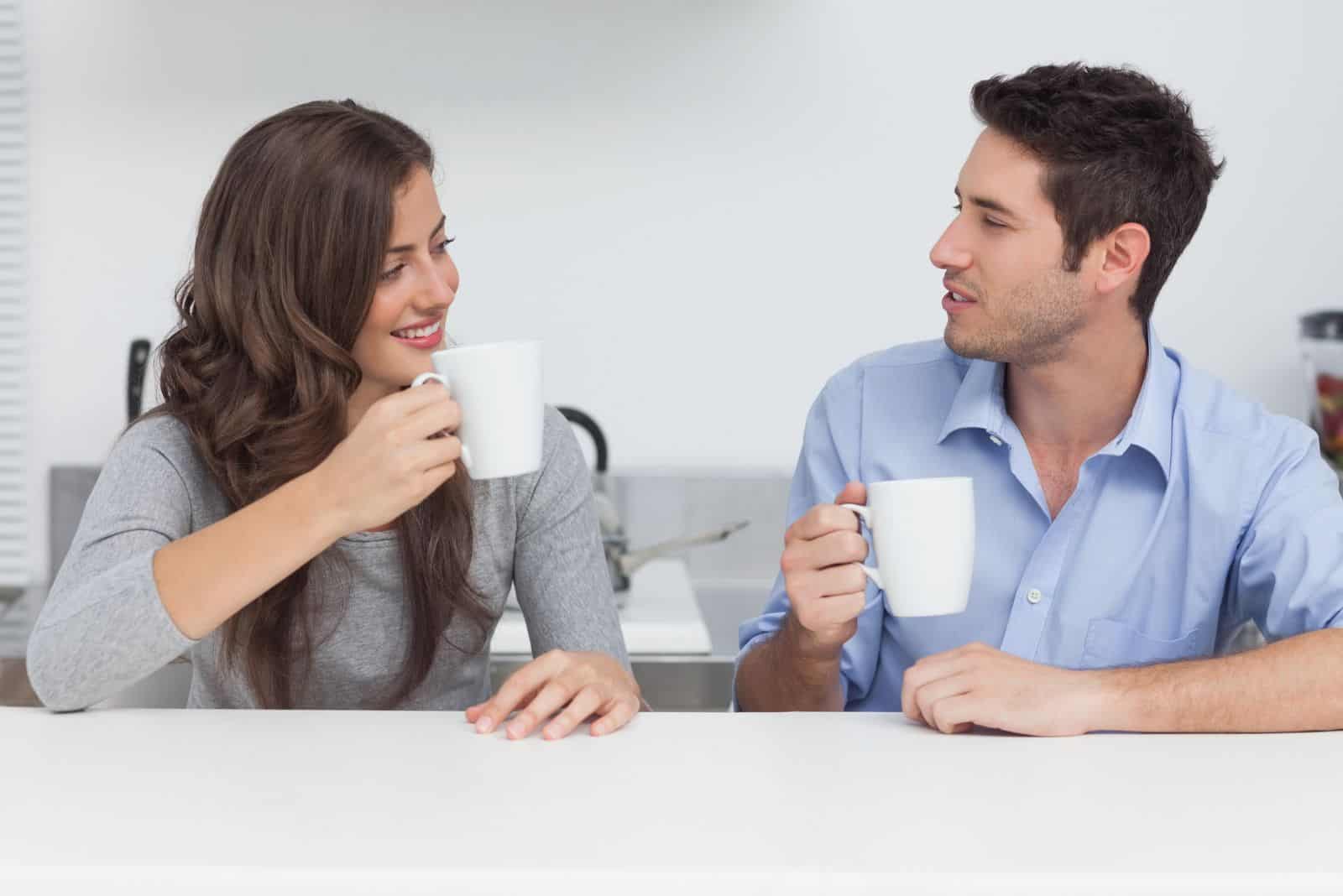mies ja nainen juovat kahvia ja puhuvat
