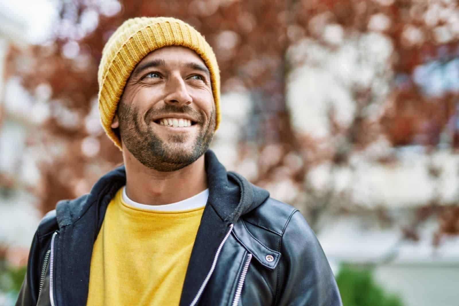 Komea latinalaisamerikkalainen mies, jolla on parta hymyilevä onnellinen ulkona