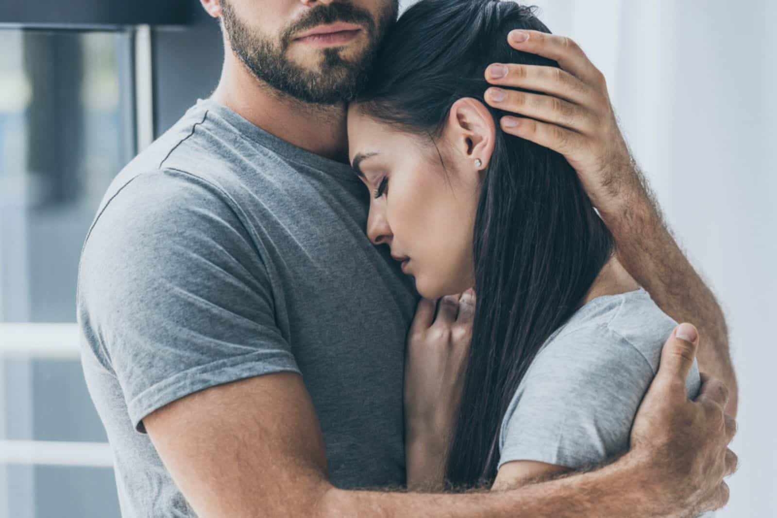 mies halaa ja tukee nuorta surullista naista