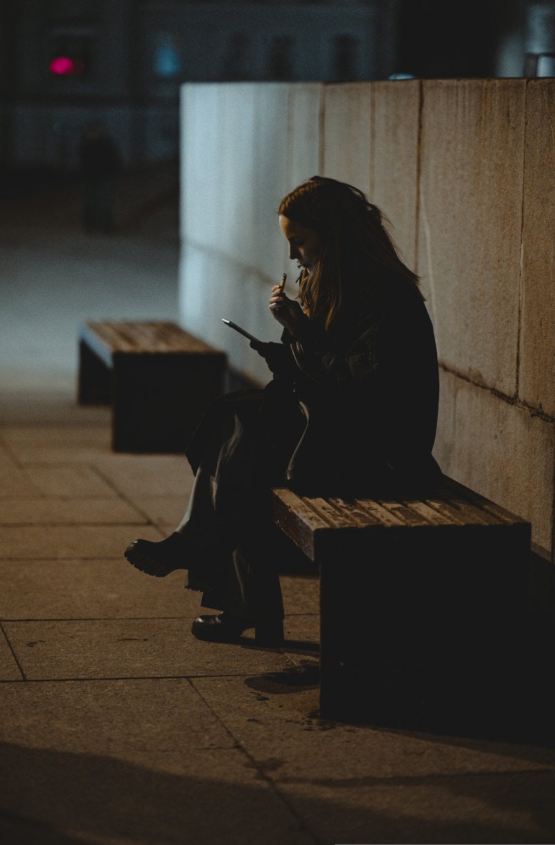A woman checks her phone in a public space. photo &ndash; Free Blue Image on  Unsplash