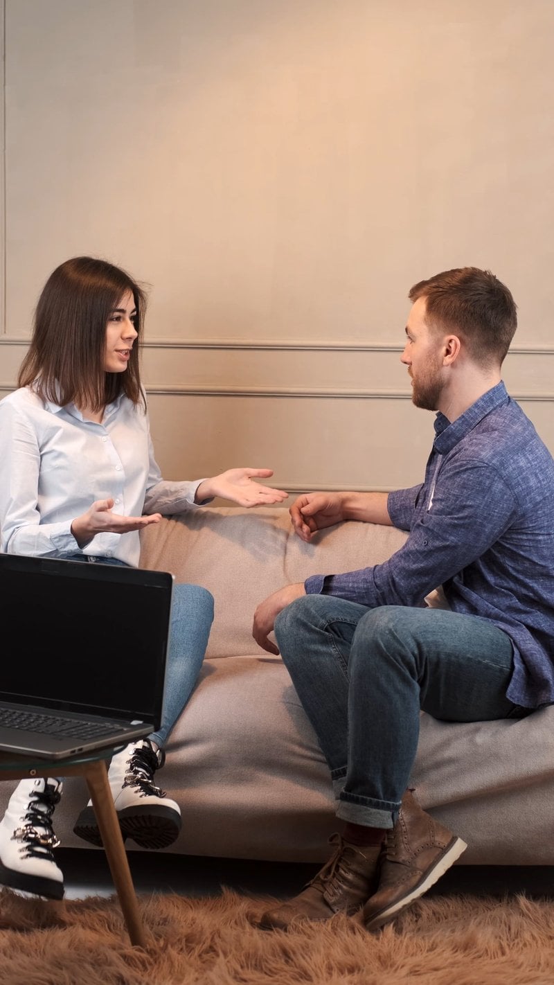 A Young Couple Arguing while Sitting on a Sofa