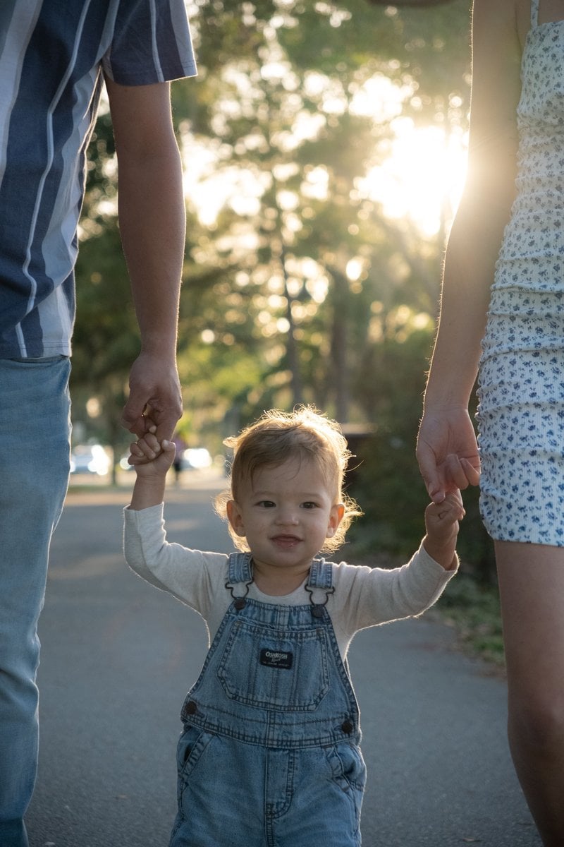 Boy Holding Hands with Mother and Father and Walking at Park &middot; Free Stock  Photo