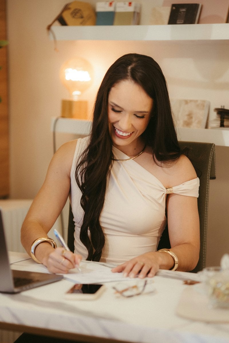 Smiling woman writing at a desk with a pen - Free Photo on ...