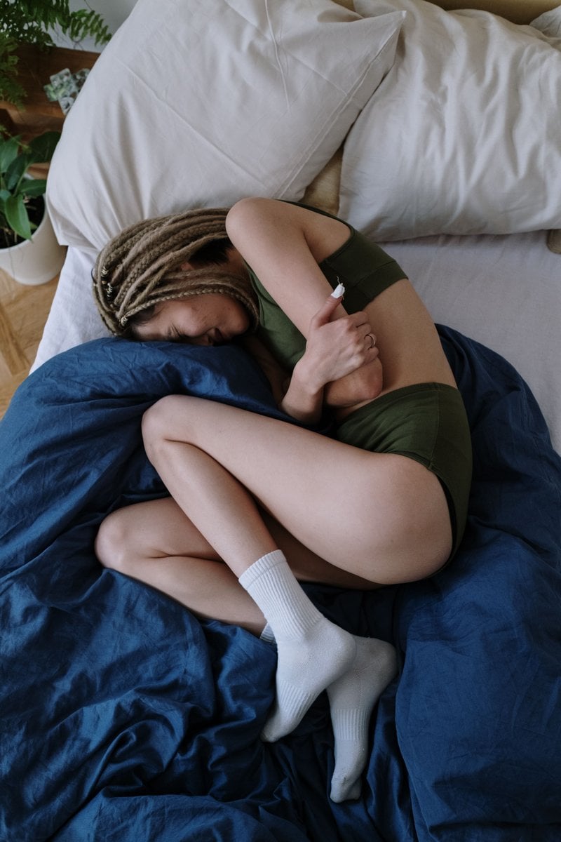 Woman Suffering from a Stomach Pain Lying Down on Bed &middot; Free Stock Photo