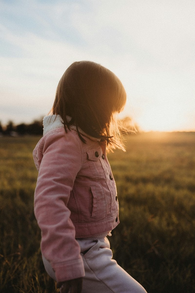 A little girl standing in a field of grass - Free Photo on Unsplash