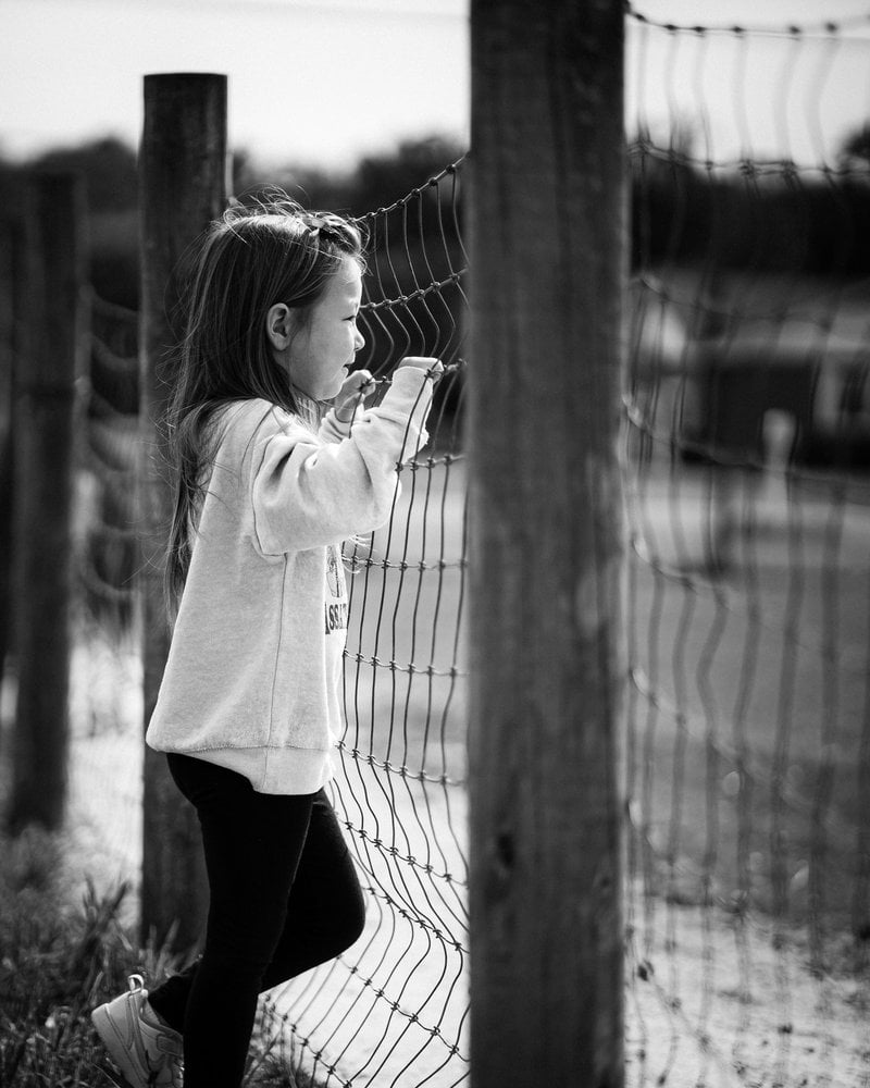 A little girl standing next to a fence - Free Photo on Unsplash